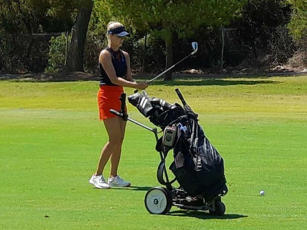 Jugadora de golf provista de una bolsa de palos con carro eléctrico. Jugadora de golf provista de una bolsa de palos con carro.